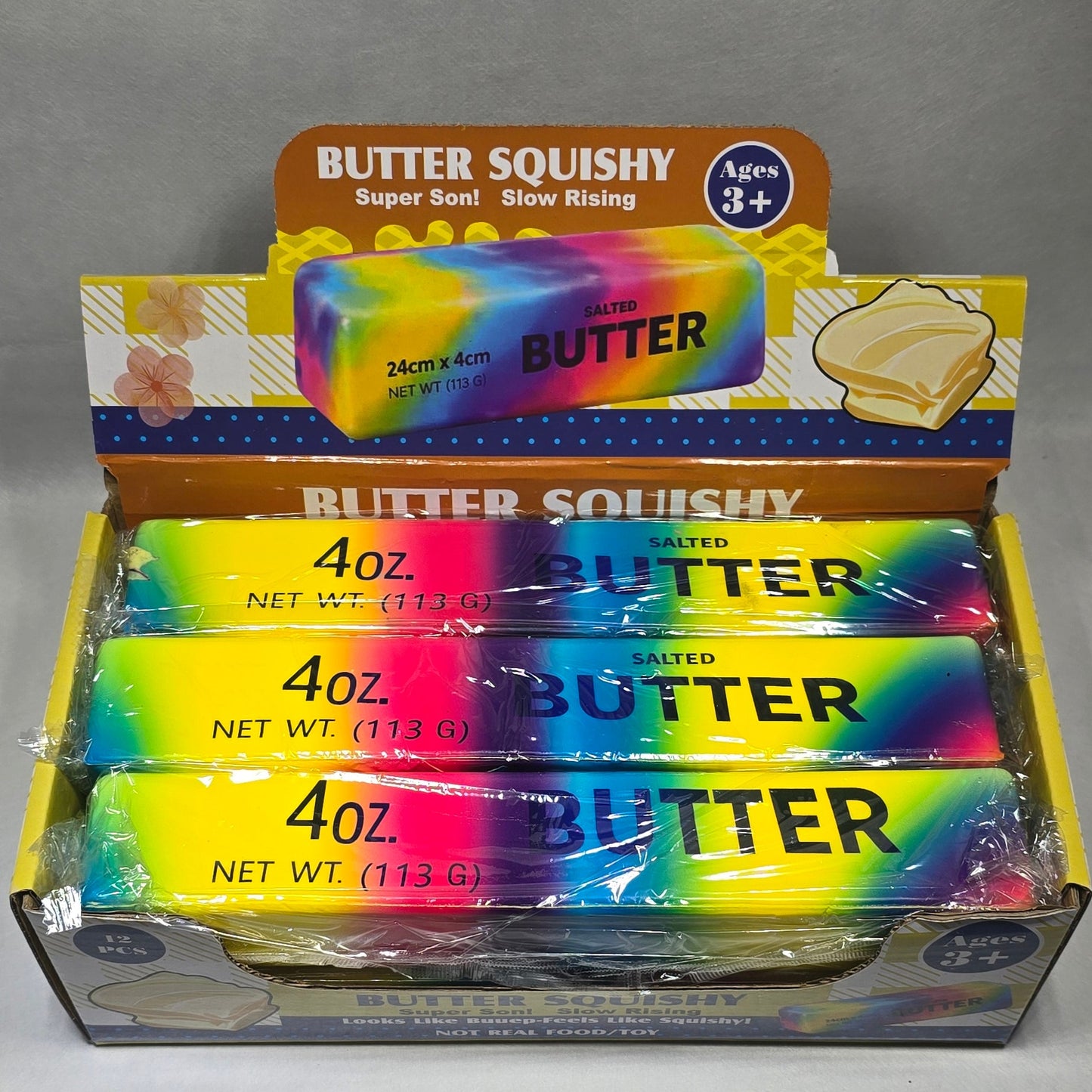 A boxed pack of Butter Squishy 4 oz tubs of spread, shown in its retail packaging on a gray surface.