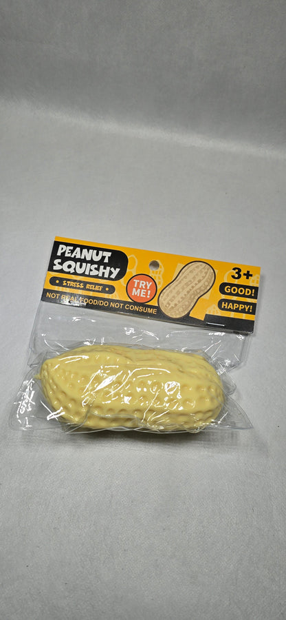A packaged novelty peanut-shaped object in clear plastic with a yellow and black retail card backing, photographed on a light gray surface.